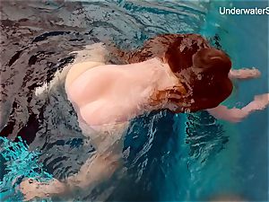red-haired Simonna demonstrating her assets underwater
